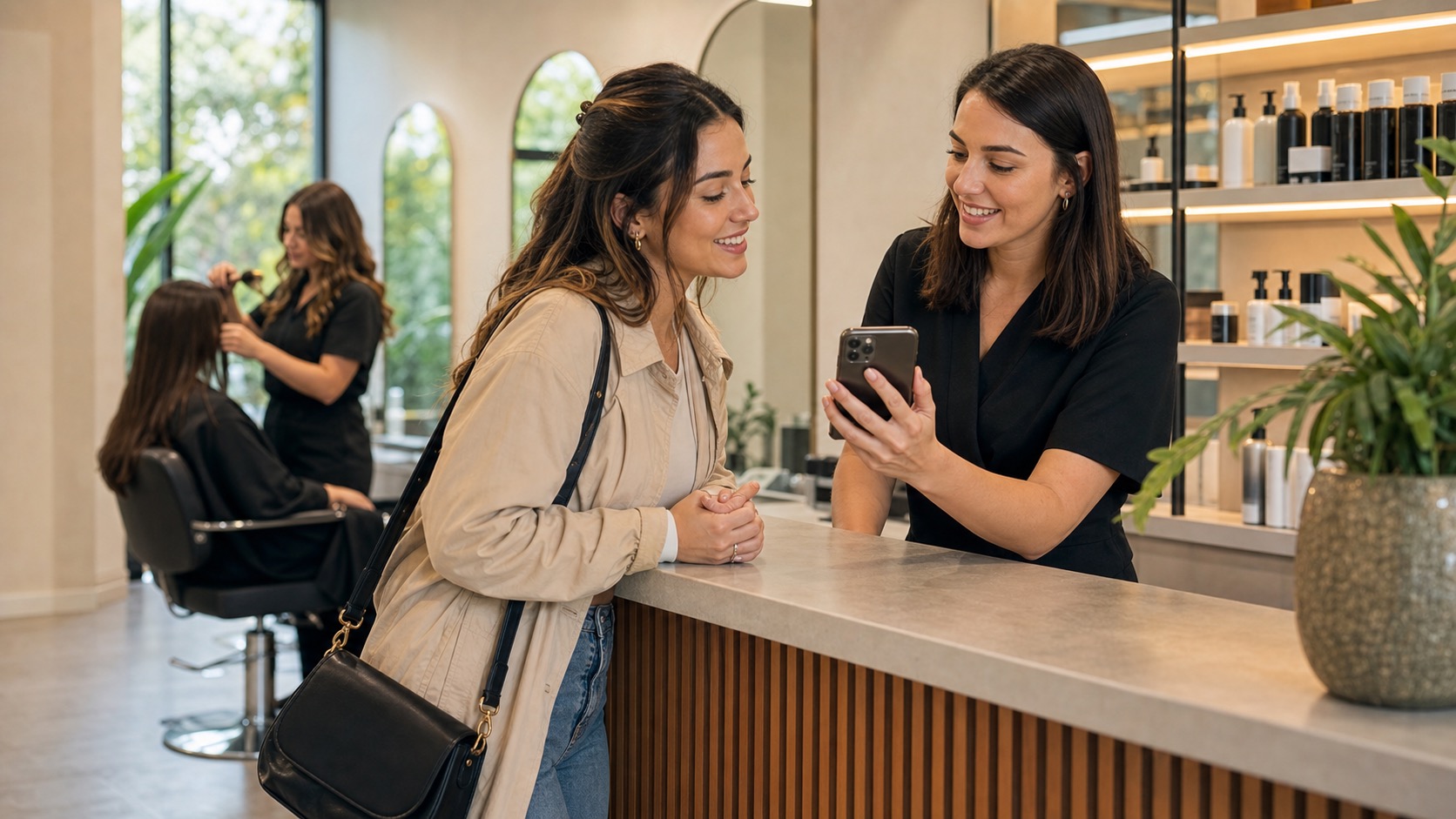 Rececionista de salão em Portugal a mostrar a uma cliente um perfil de Instagram com link de marcação no telemóvel